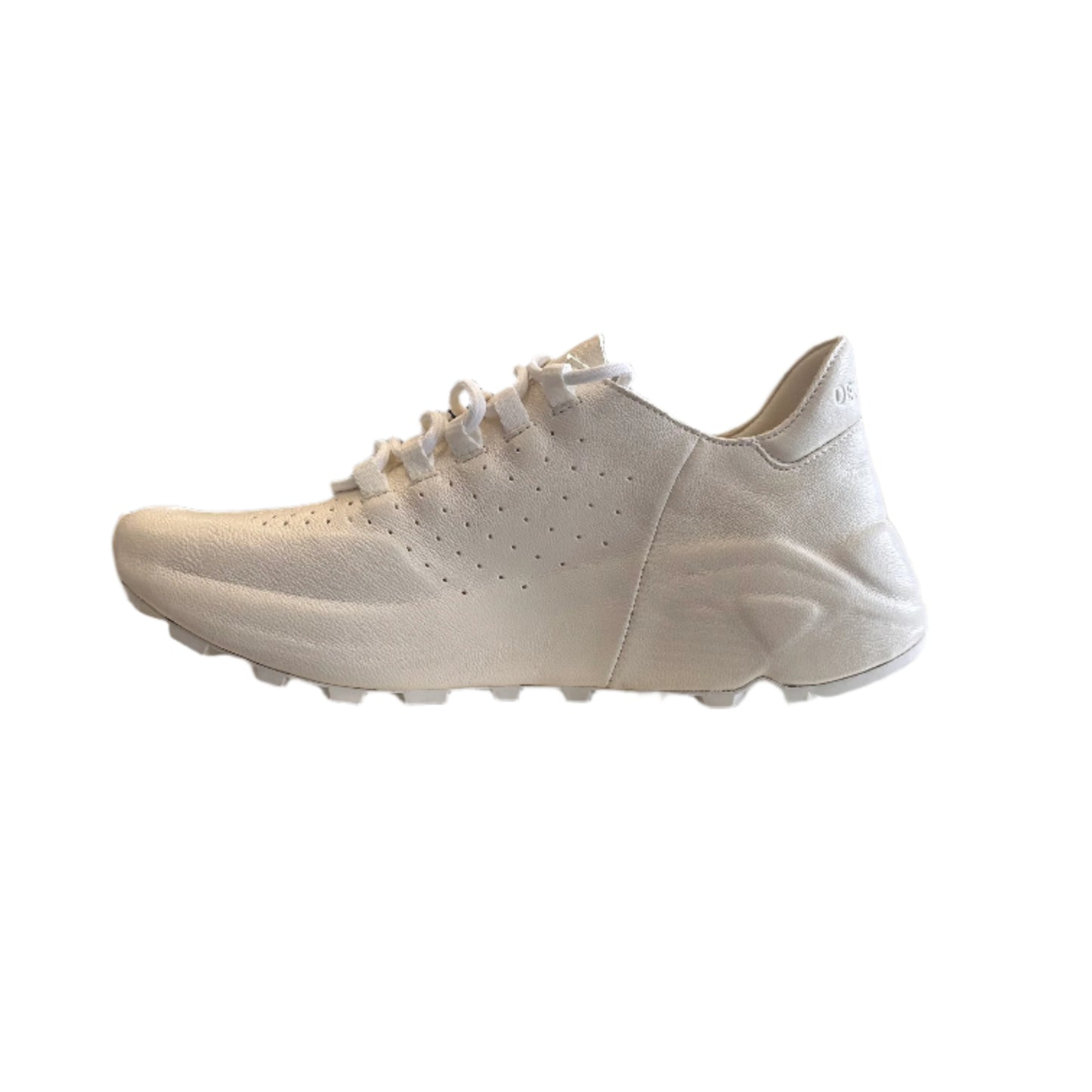 White sneaker leaning against a white cabinet in a room with clothing racks and a mirror.