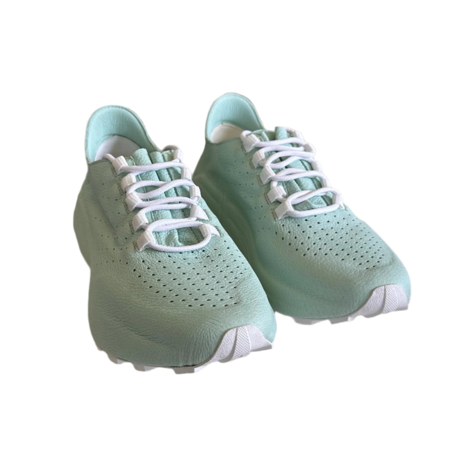 Pair of light green sneakers with white laces on a white surface.