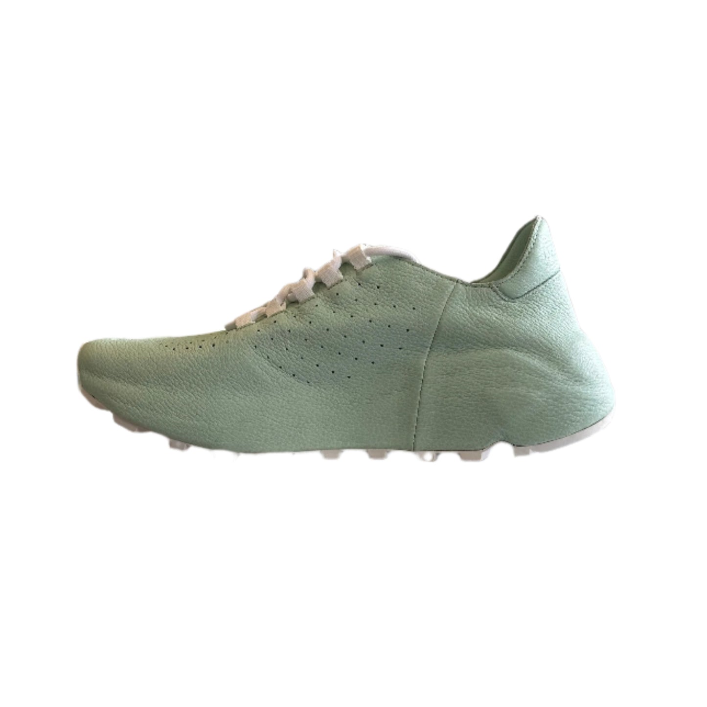 Light green sneaker displayed on a white stand in a store setting with various items in the background.