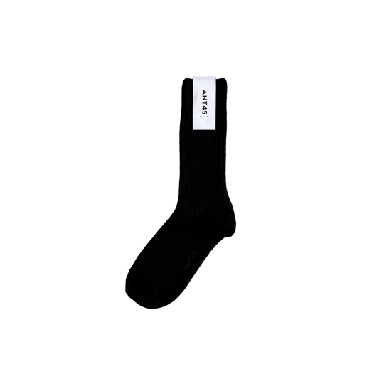 Black sock with a brand label on a wooden floor