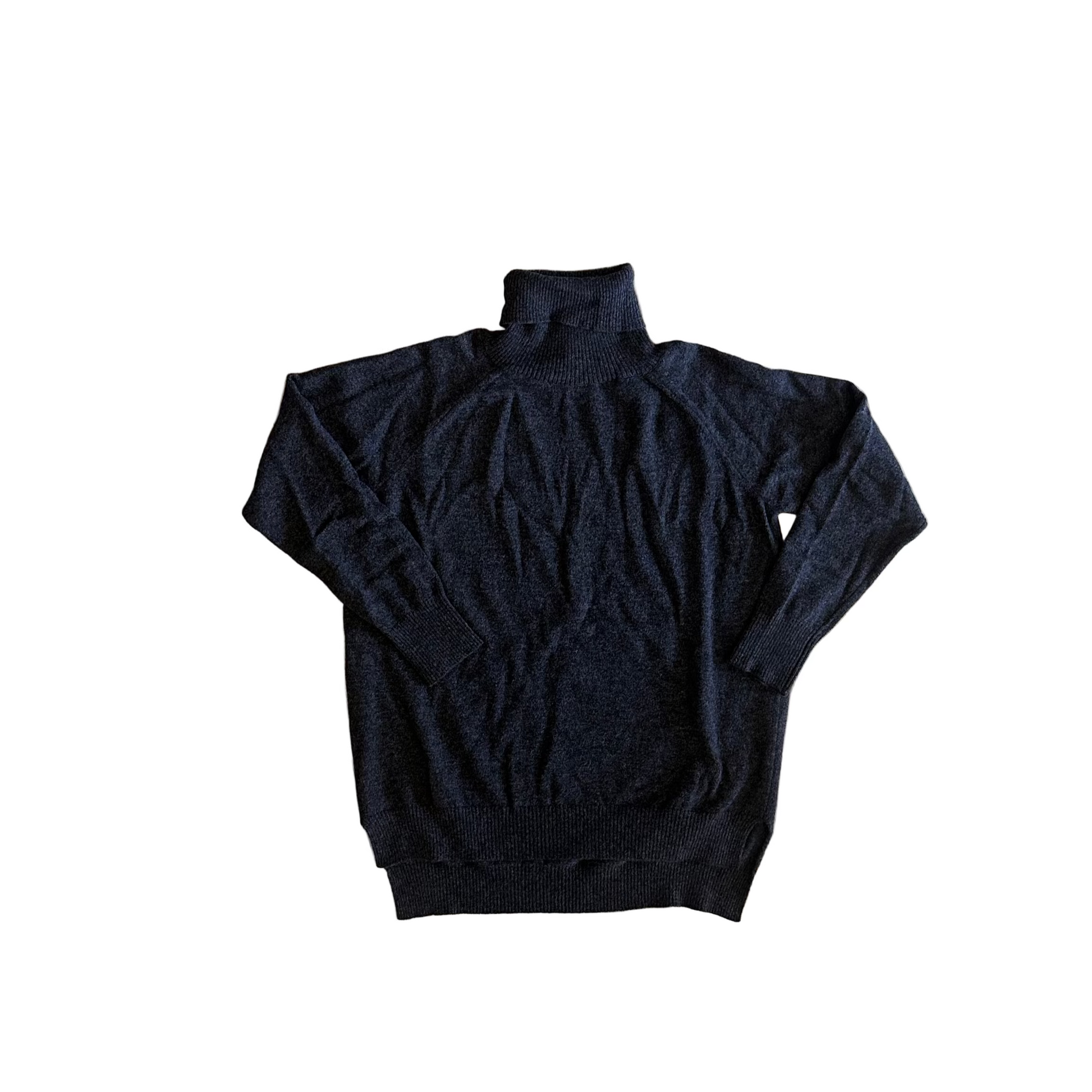 Black turtleneck sweater on a wooden floor with a person wearing brown shoes and pants.